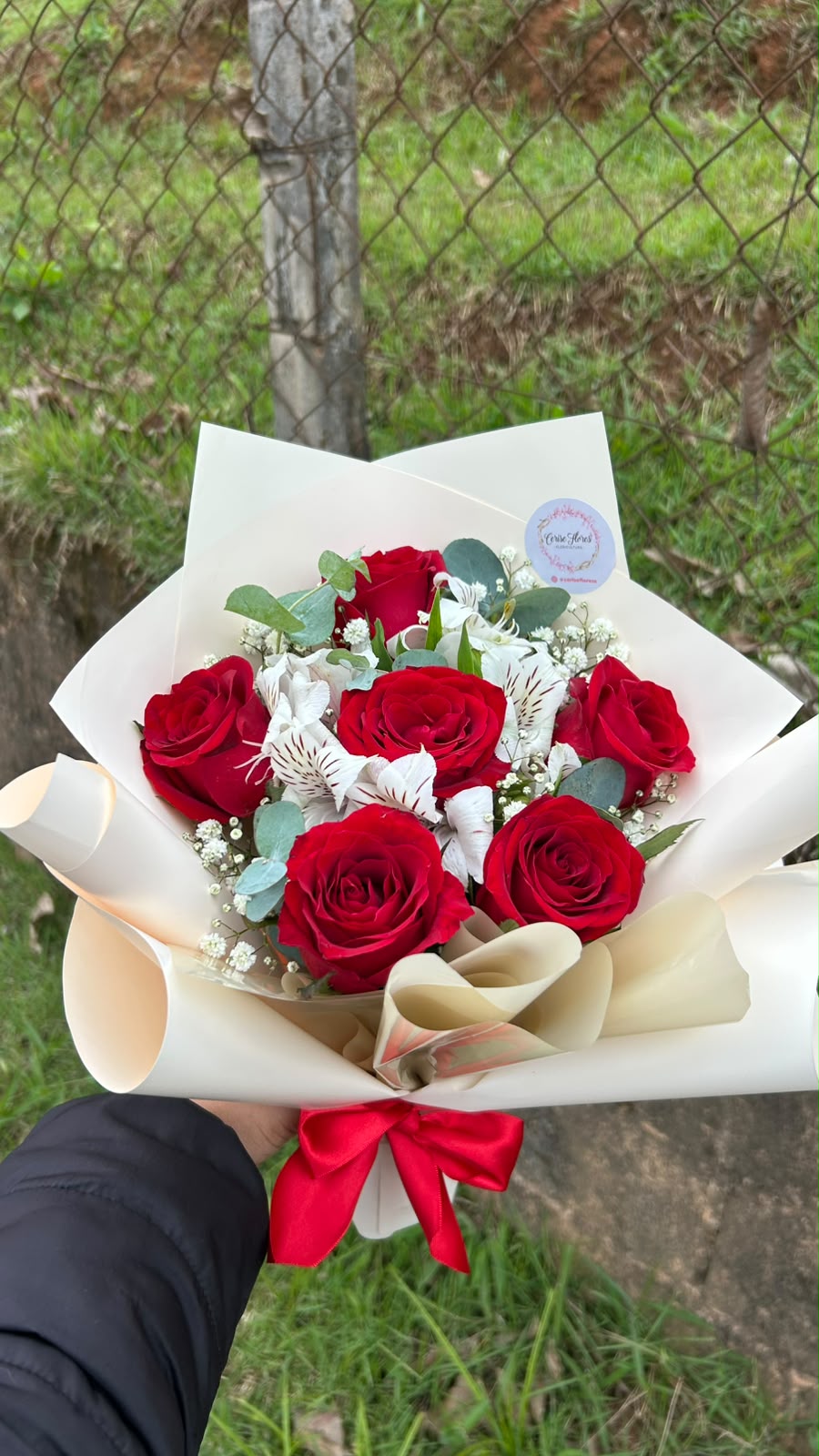 Buquê de rosas vermelhas com alstroemérias brancas e eucalipto em papel creme e laço vermelho
