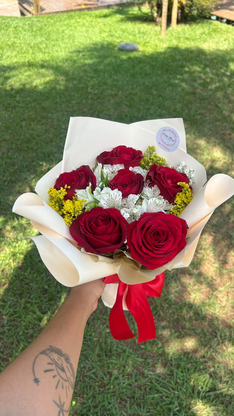 Buquê de rosas vermelhas com alstroemérias brancas e solidago amarelo em papel creme